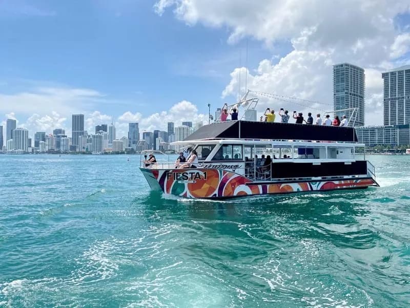 Colorful Fiesta boat on Biscayne Bay with Miami skyline behind