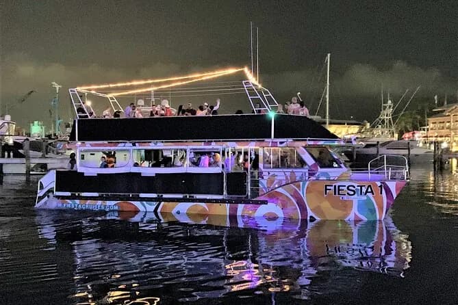 Fiesta boat docked at the marina lit up at dusk