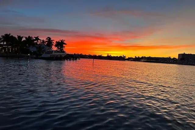 Sunset reflected on the water beside a private boat